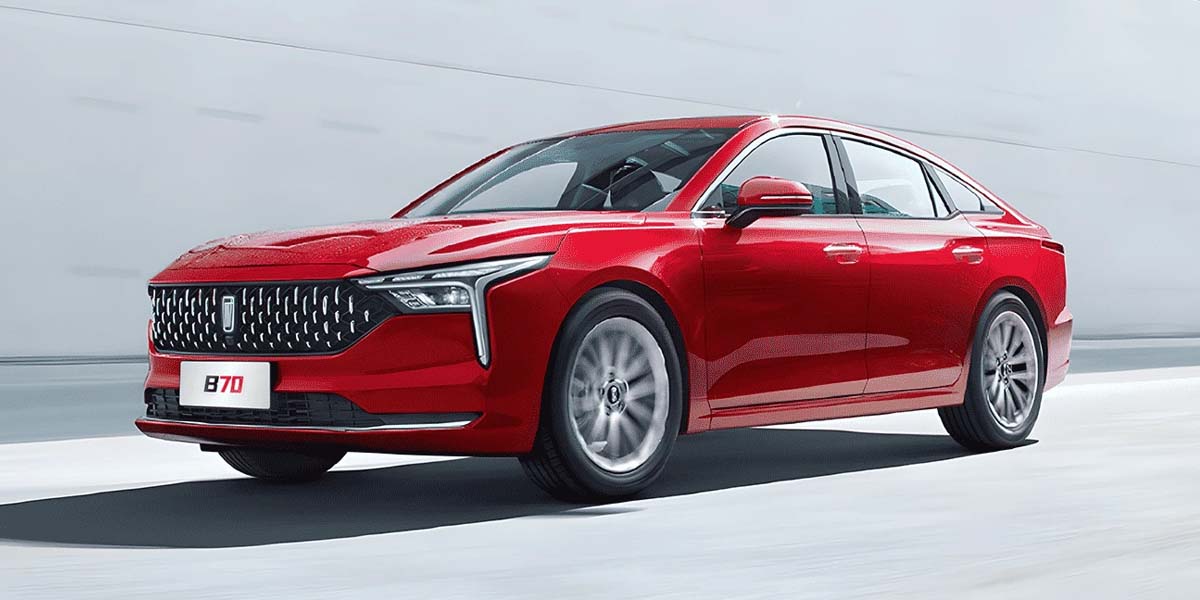 A sleek red B70 sedan cruising smoothly on a modern road, showcasing its stylish design and dynamic presence.